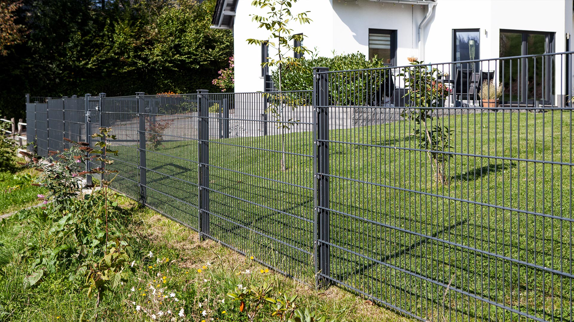 Doppelstabmattenzaun vor einem Haus mit Wiese